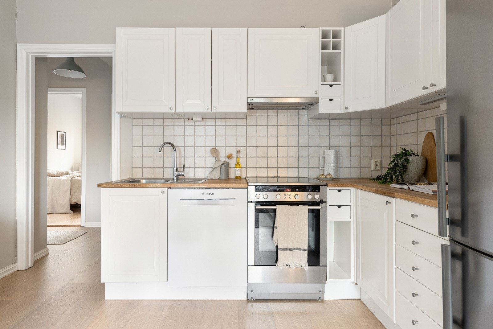 Leiligheten har en åpen kjøkkenløsning mot stuen med en stilren kjøkkeninnredning som fikk nye fronter i 2024. Galleribilde