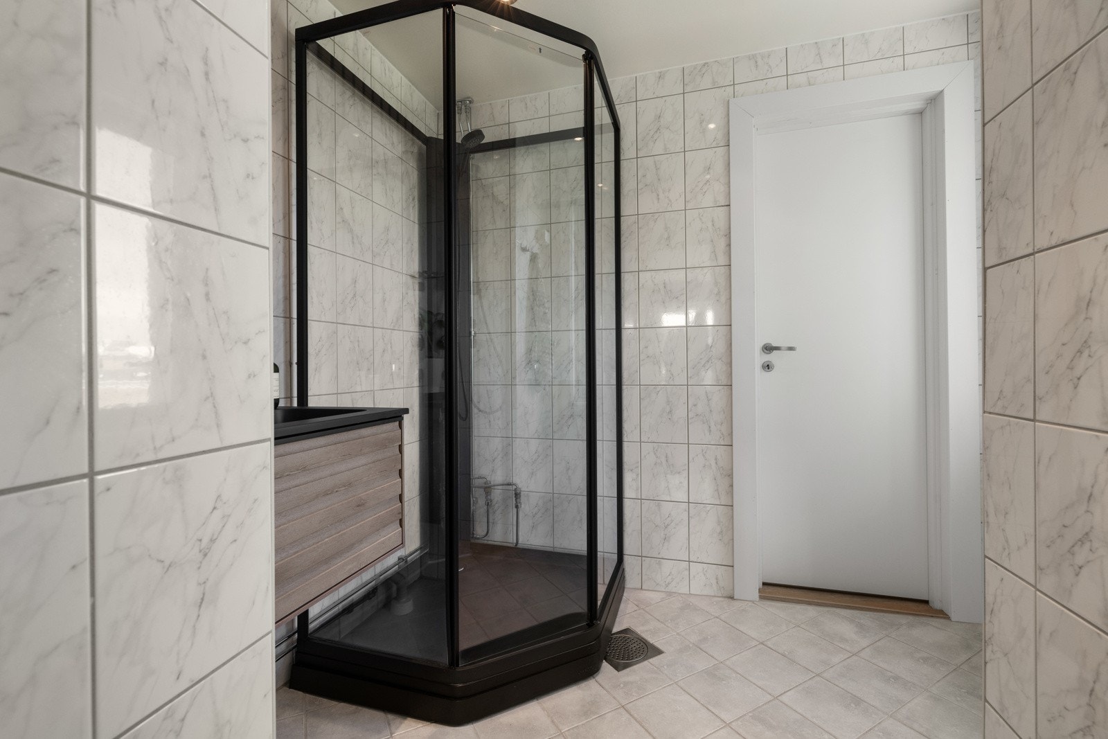 Badet har lyse, marmorerte fliser på gulv og vegger, gulvvarme og downlights, dusjkabinett nytt fra 2023 Galleribilde