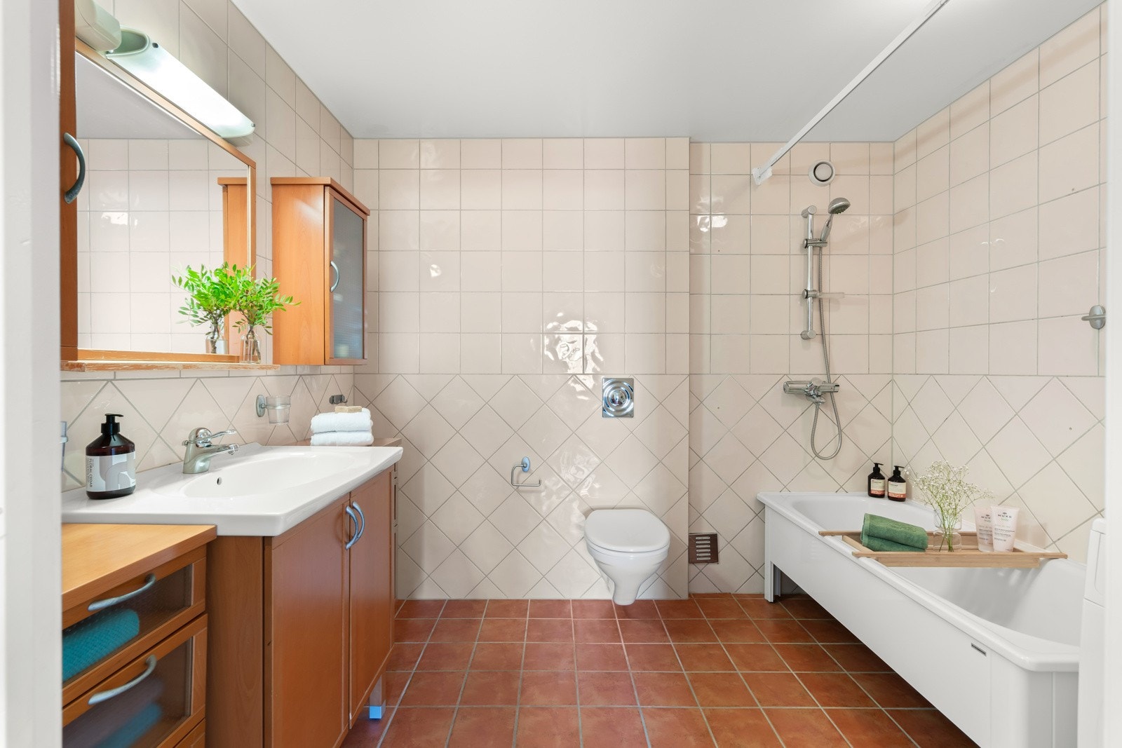 Stort flislagt baderom bad med opplegg for vaskemaskin og tørketrommel. Galleribilde