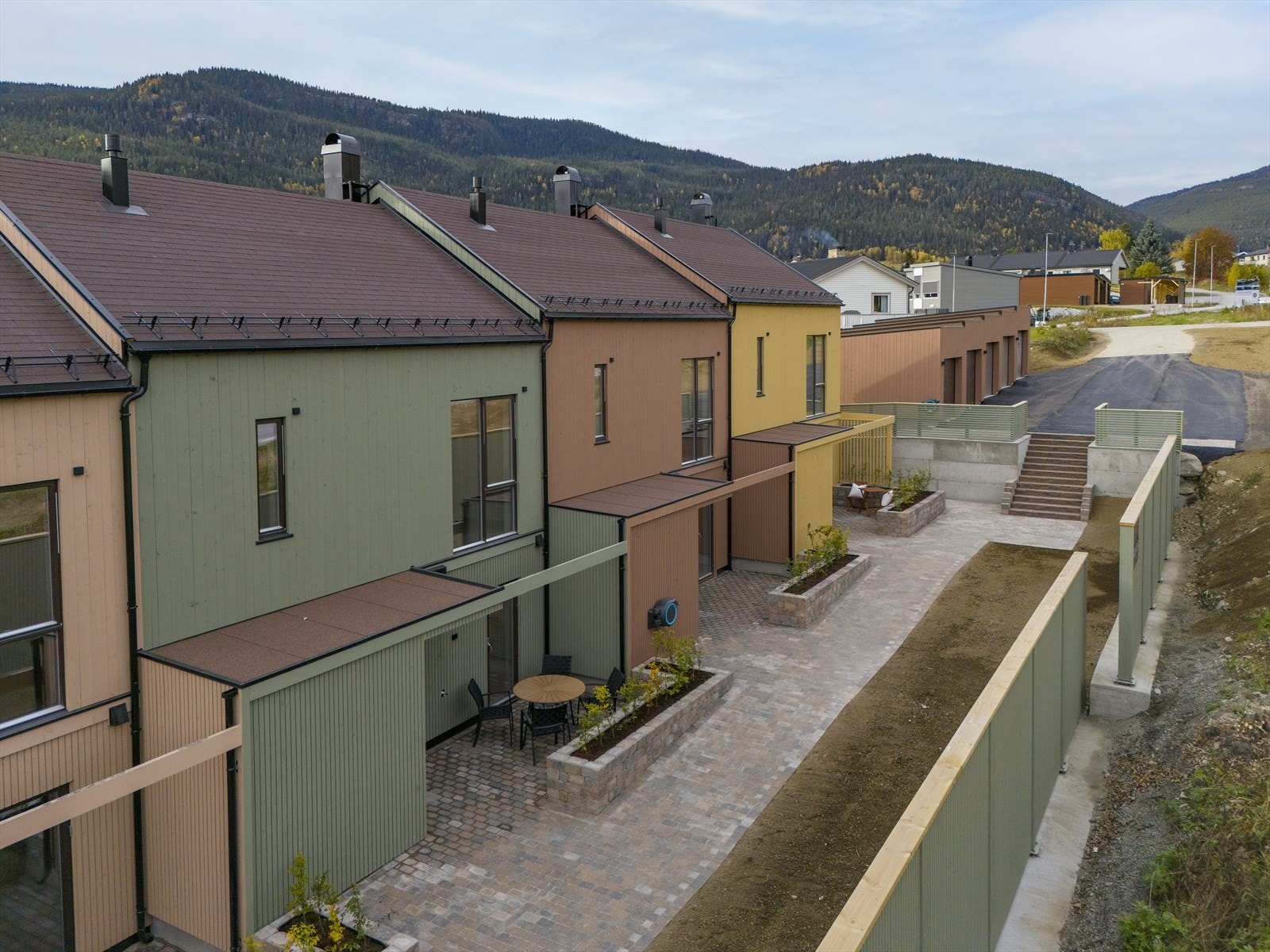 Uteområdene er meget pent opparbeidet med steinlagte arealer rundt inngangspartiene og blomsterkasser som er beplantet med busker. I tillegg er det spilevegger og gjerder rundt eiendommen som harmonerer fint med byggene som er satt opp. Galleribilde