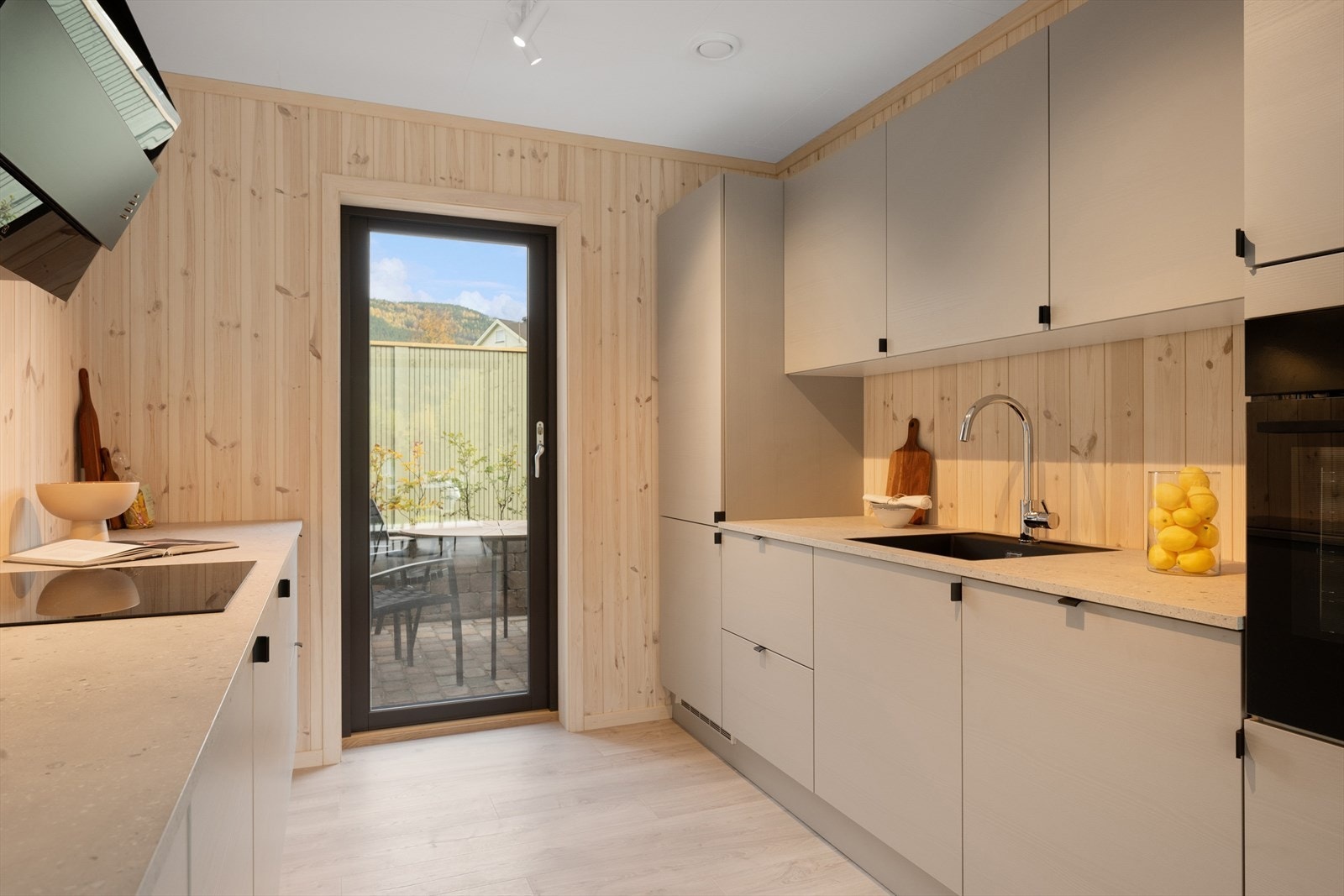 Høykvalitets hvitevarer bestående av integrert stekeovn, induksjonstopp, oppvaskmaskin og kombiskap fra Electrolux. Galleribilde