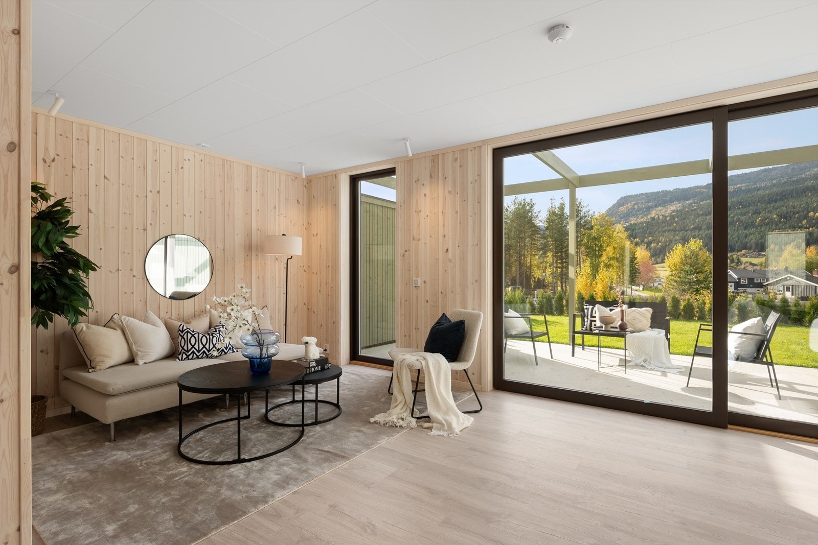 Stuen har store vindusflater langs hele veggen som slipper inn rikelig naturlig lys og det er et flott utsyn mot hagen. Her er det også direkte adgang ut til en privat terrasse og hageparsell. Galleribilde