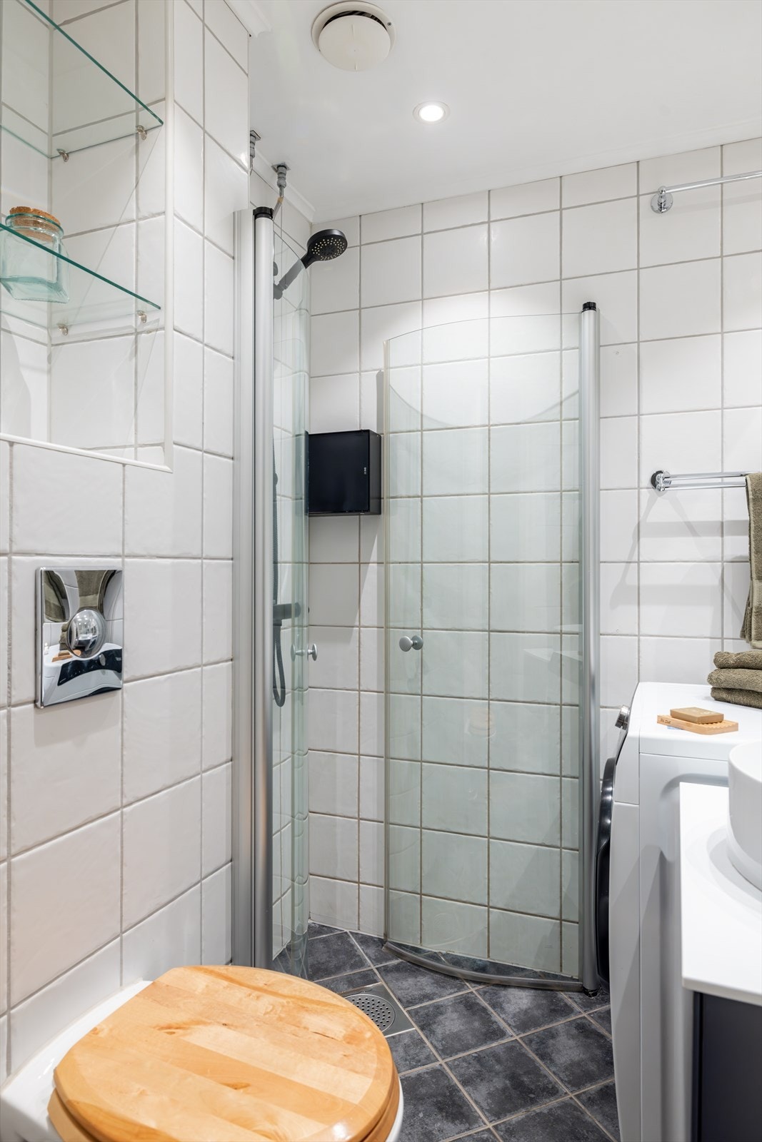 Downlights i himling. Praktiske glasshyller på vegg samt oppbevaring i servantskuff. Galleribilde