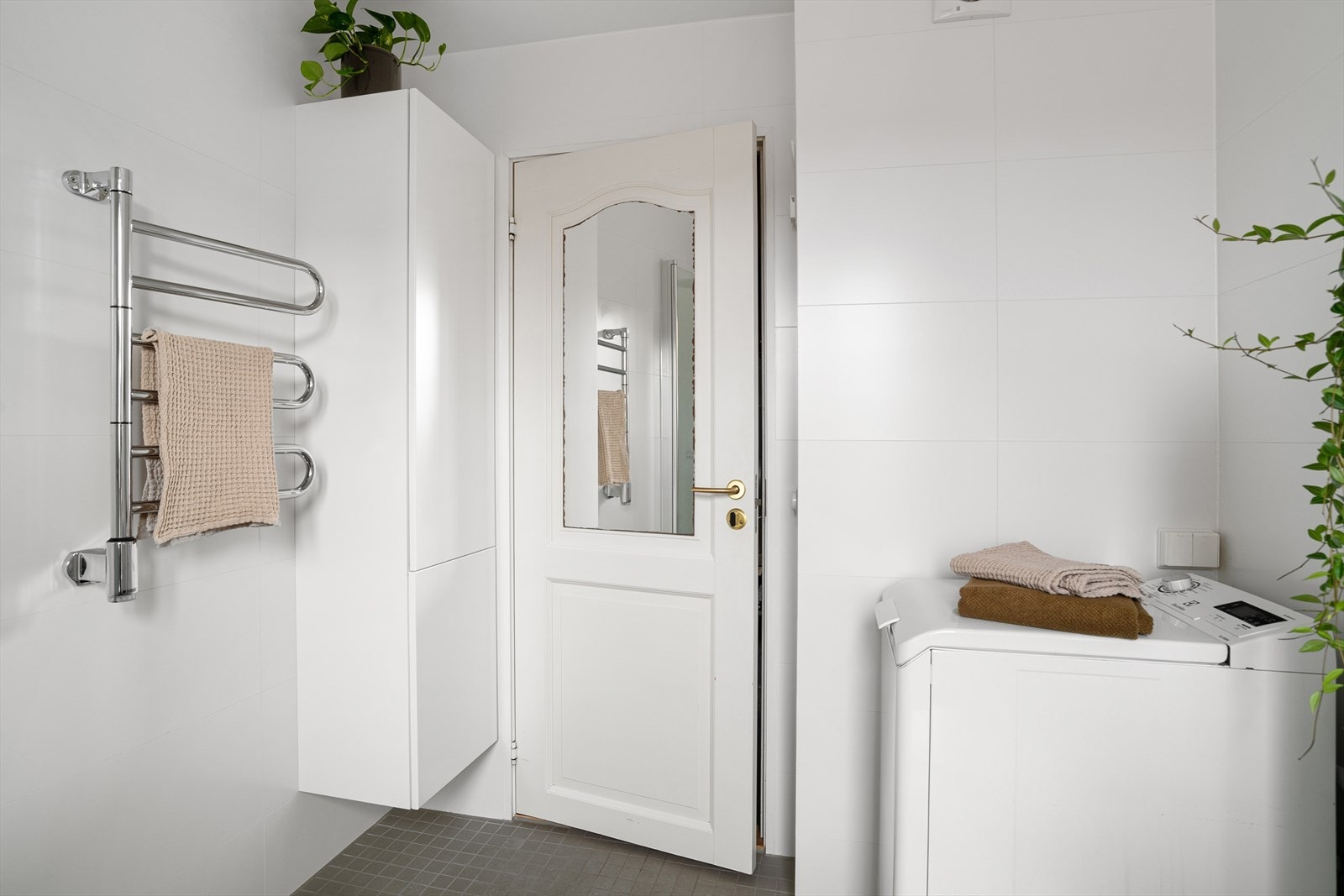 Opplegg for vaskemaskin og god oppbevaringsplass i ekstra skapinnredning. Elektrisk veggmontert håndkletørker. Galleribilde