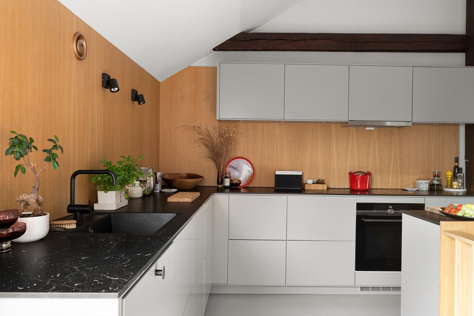 Eik finerplater er montert på veggene over benken for å myke opp det stramme og minimalistiske uttrykket. Galleribilde