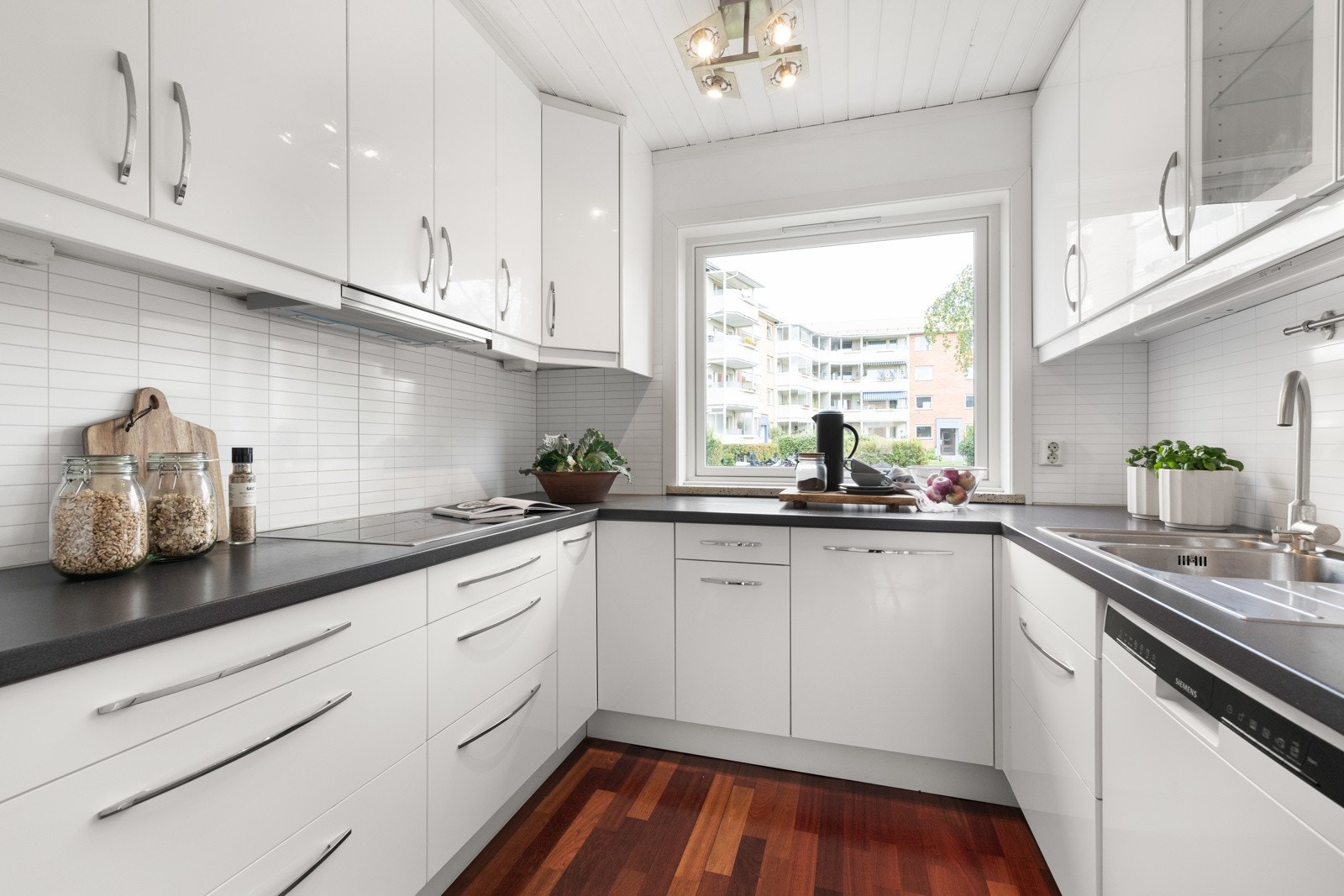 Kjøkkenet har et tidsmessig og pent design med gode benkeflater og rikelig med oppbevaringsplass Galleribilde