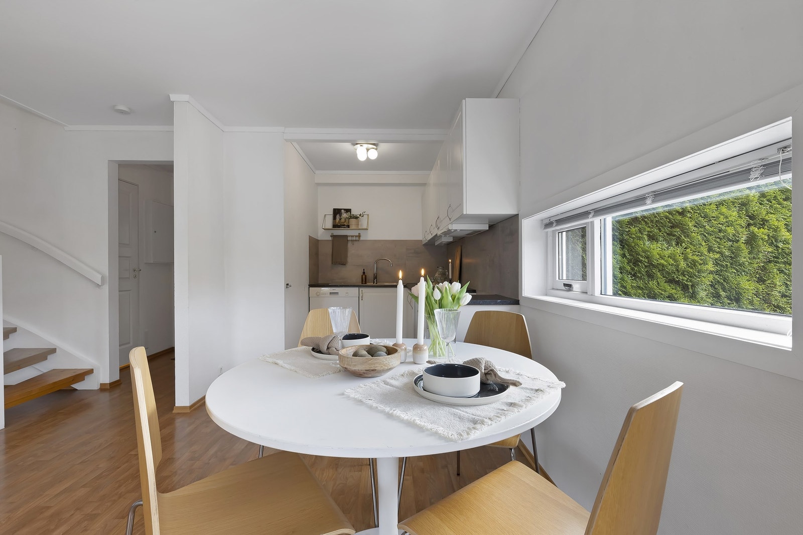 Kjøkken med åpen løsning mot stue og plass til spisebord med vindu mot terrassen. Galleribilde