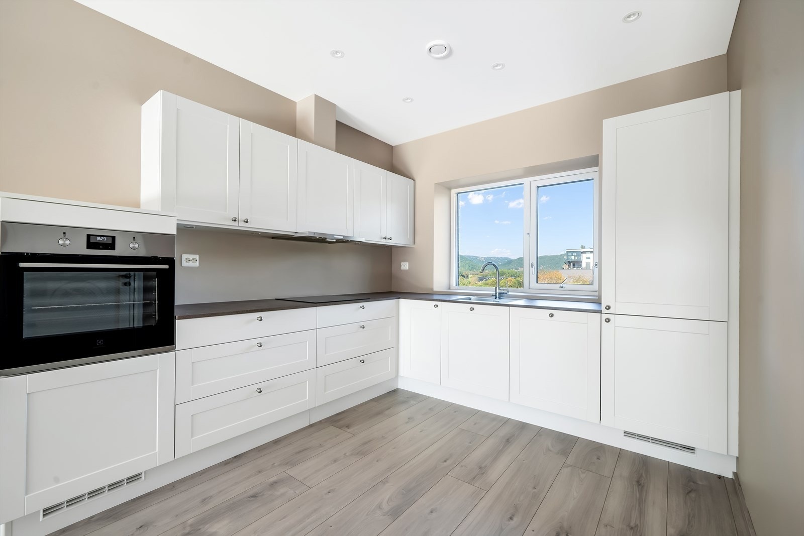 Stilrent kjøkken fra Strai med integrerte hvitevarer. Opphøyet komfyrløsning for lettere arbeid. Galleribilde