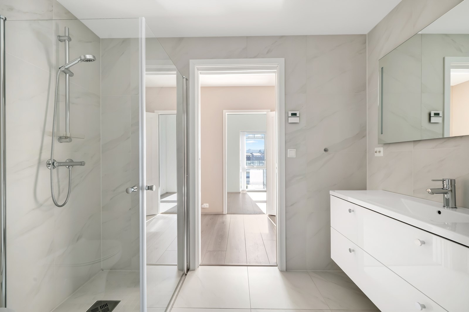 Flislagt bad innredet med baderomsinnredning, toalett og dusjhjørne. Galleribilde