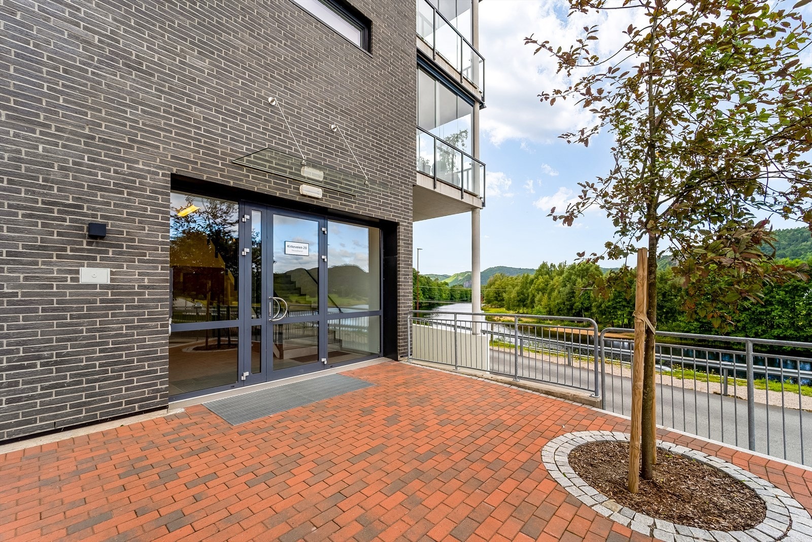 Inngang til bygget med callinganlegg med adgangskontroll. Heis i bygget. Galleribilde