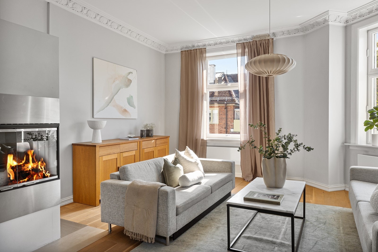 Leiligheten har en lys og herlig hjørnestue med nydelig stukkatur, peis og store vindusflater. Galleribilde