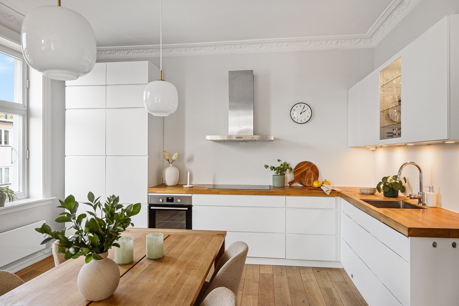 Moderne innredning fra Kvik (2012/21) med hvite, glatte fronter og benkeplate i heltre eik. Galleribilde