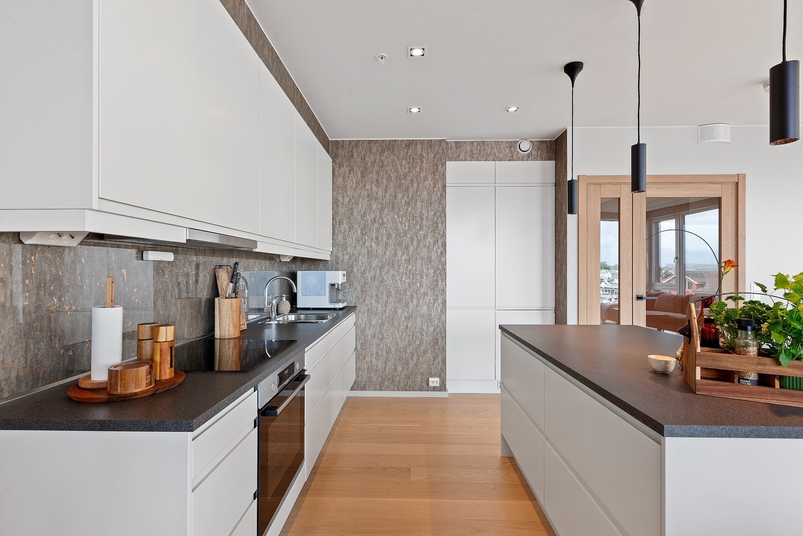 Innredningen har glatte hvite fronter med integrerte gripelister og en pen laminatbenkeplate. Galleribilde