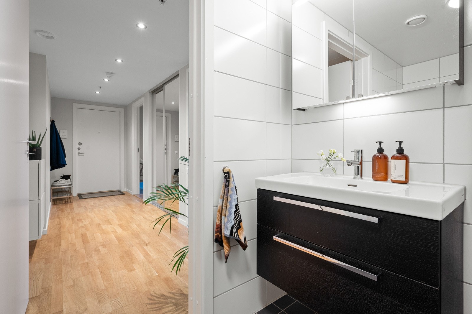 Stilren innredning med heldekkende servant og skuffer, speilskap med integrert belysning. Galleribilde