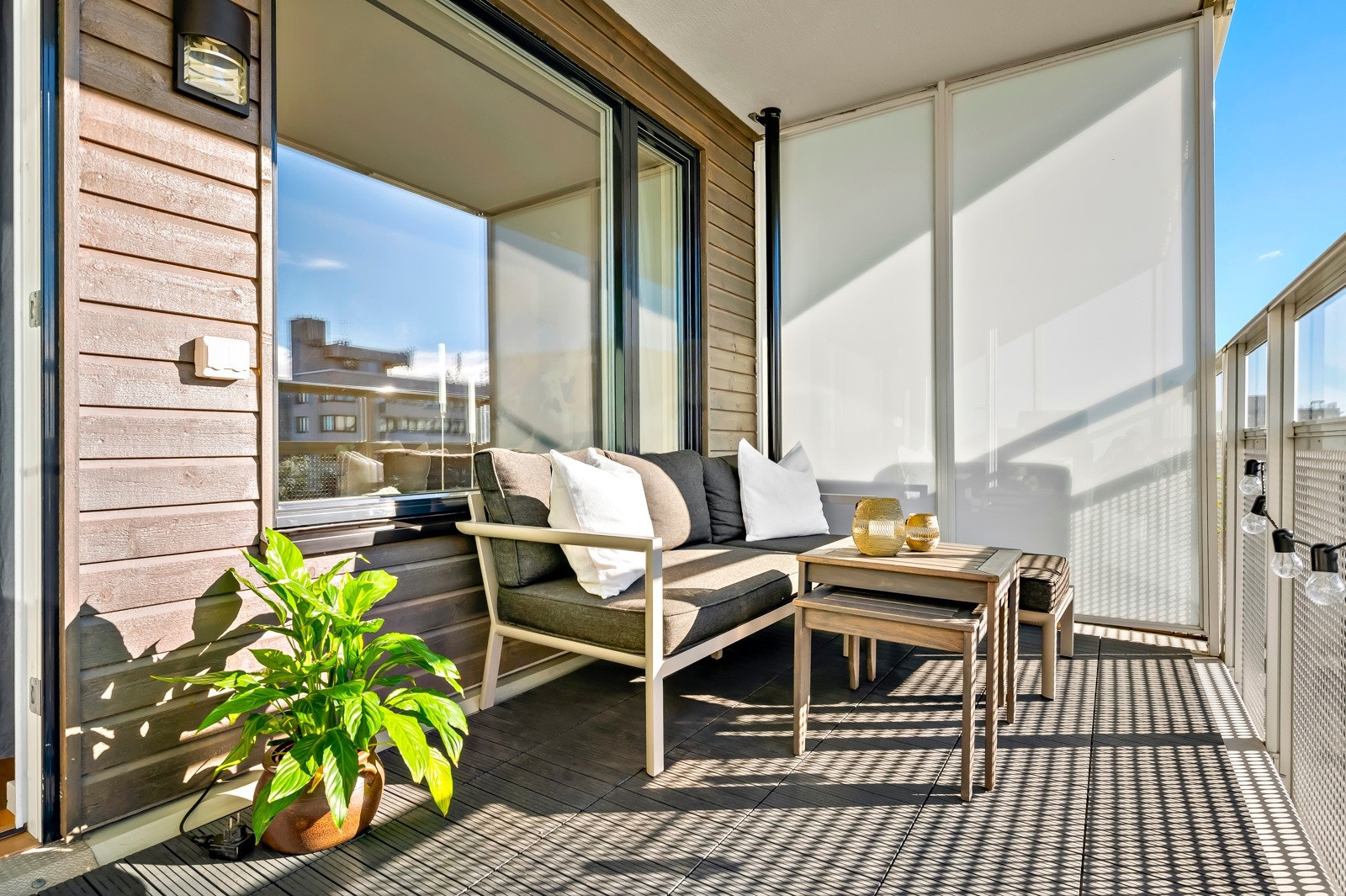 Balkongen i betongkonstruksjoner med tremmer på gulv. Strømuttak og belysning. Galleribilde