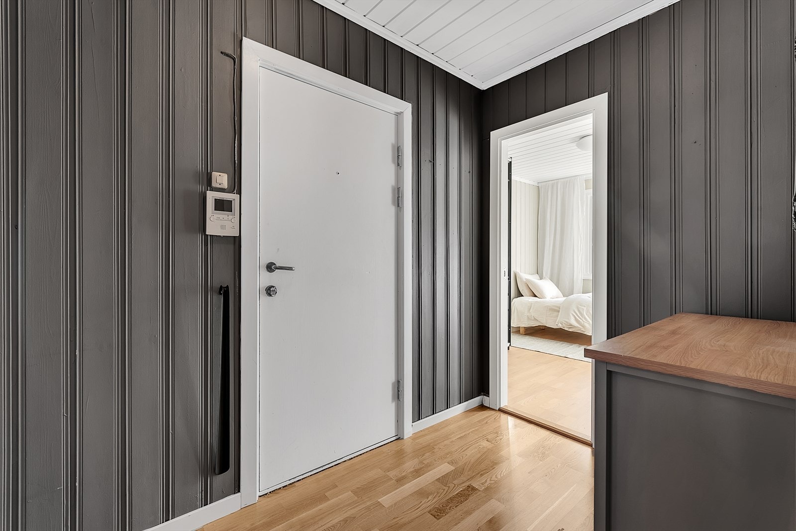 Entré med parkett på gulv, malt panel på vegger og malt panel i tak. Det er montert calling anlegg med døråpner som man kan enkelt slippe inn gjester. Galleribilde