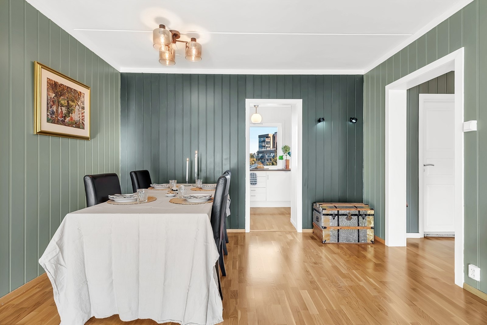 Lys og romslig stue med parkett på gulv, malt mdf-panel på vegger og malt tak. Her er det god plass for både sofagruppe samt spisemøblement. Galleribilde