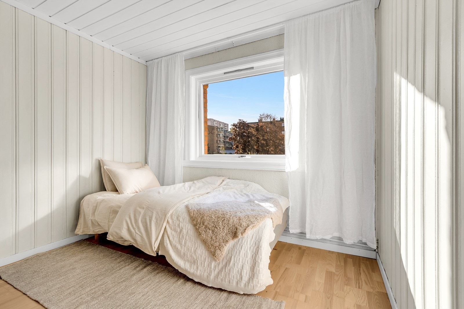 Soverom 2 med parkett på gulv, malt panel på vegger og i tak. Det er montert en praktisk skyvedørsgarderobe. Galleribilde