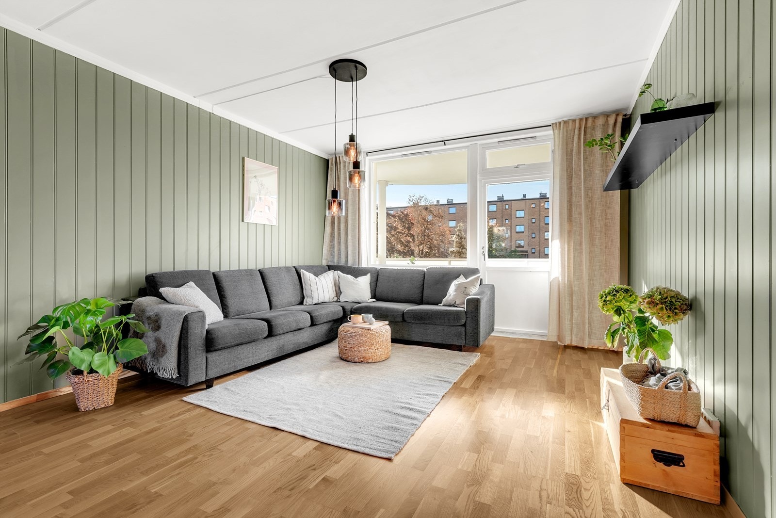 Lys og romslig stue med parkett på gulv, malt mdf-panel på vegger og malt tak. Her er det god plass for både sofagruppe samt spisemøblement. Galleribilde