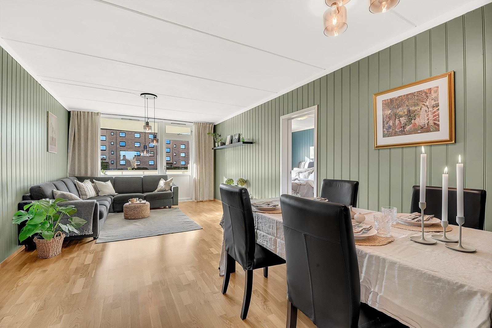 Lys og romslig stue med parkett på gulv, malt mdf-panel på vegger og malt tak. Her er det god plass for både sofagruppe samt spisemøblement. Galleribilde