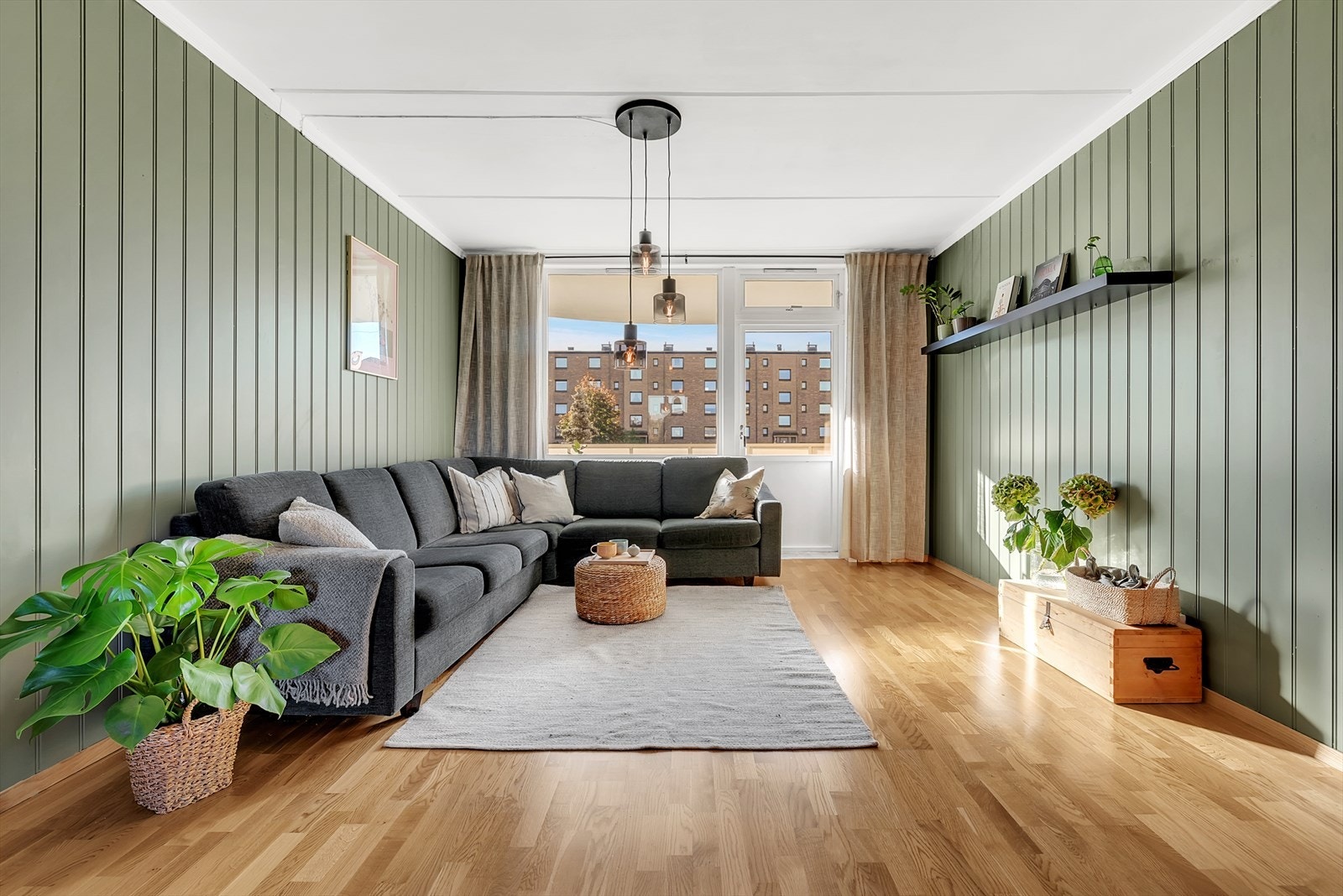 Lys og romslig stue med parkett på gulv, malt mdf-panel på vegger og malt tak. Her er det god plass for både sofagruppe samt spisemøblement. Galleribilde