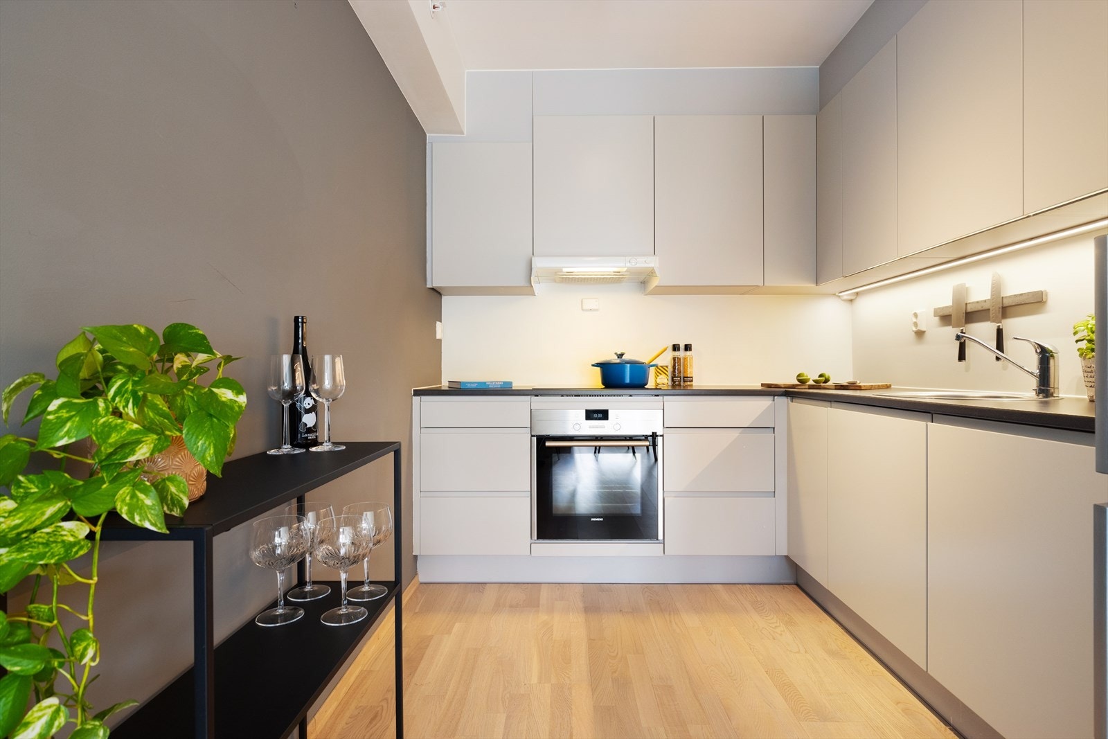 Kjøkkenet ligger i en delvis åpen løsning mot resten av stuen. Her er det en moderne kjøkkeninnredning fra Arens med lyse, glatte fronter og god skap- og benkeplass. Galleribilde