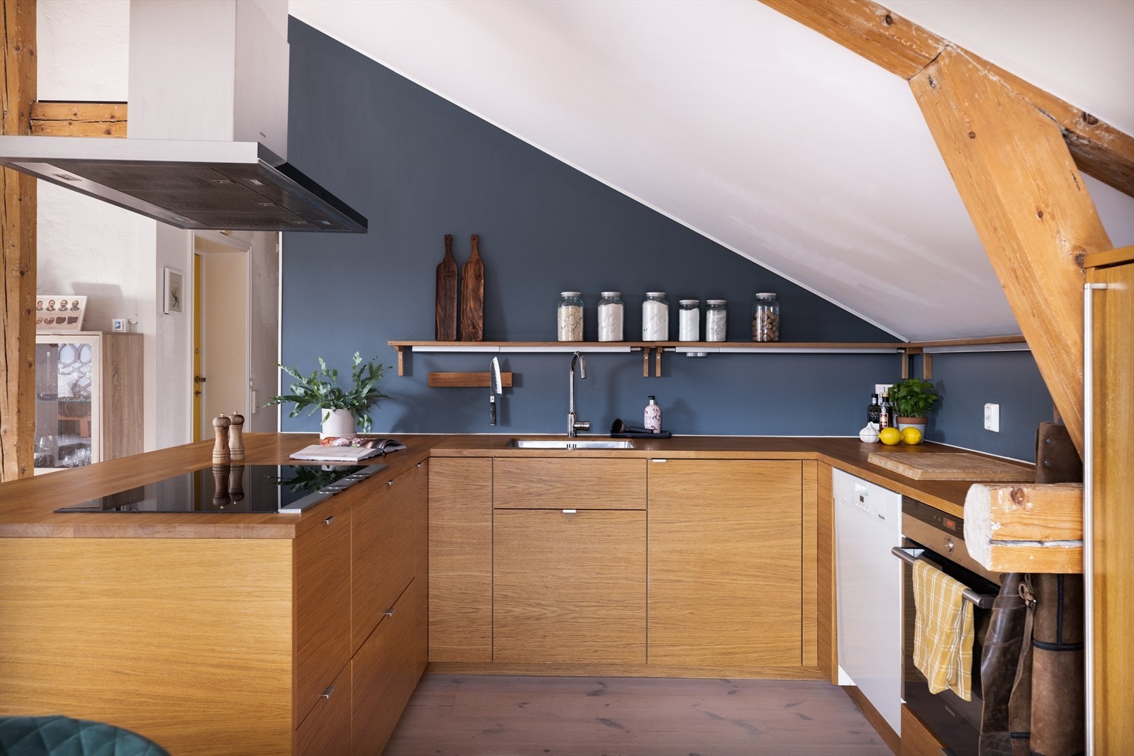 Kjøkkeninnredning med finérte fronter, benkeplate i tre og underlimt oppvaskkum i stål. Galleribilde