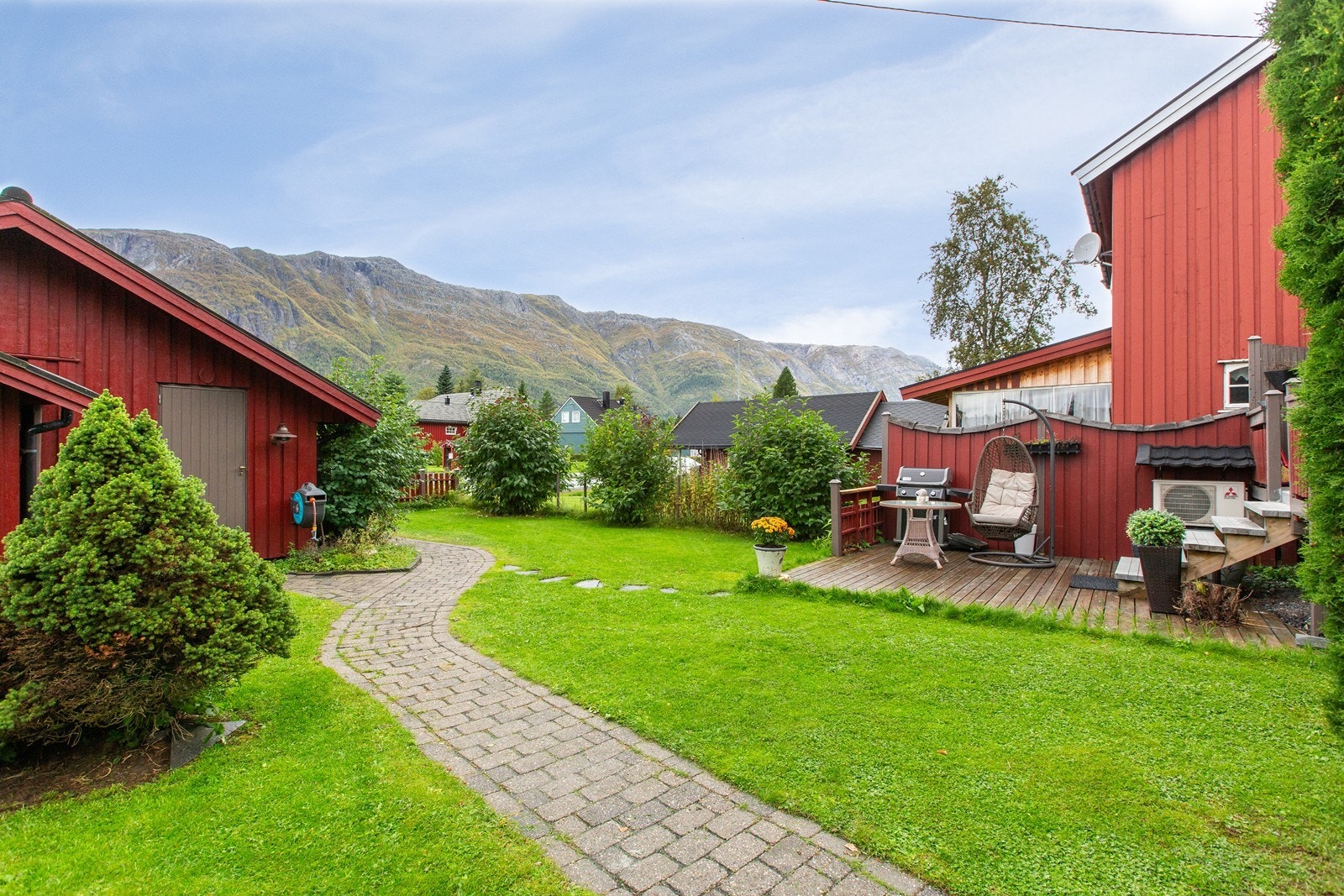 Pent opparbeidet hage. Innkjørsel foran garasje er pålagt brostein. Innover gjennom hagen er det lagt brostein inn til boligen. Galleribilde