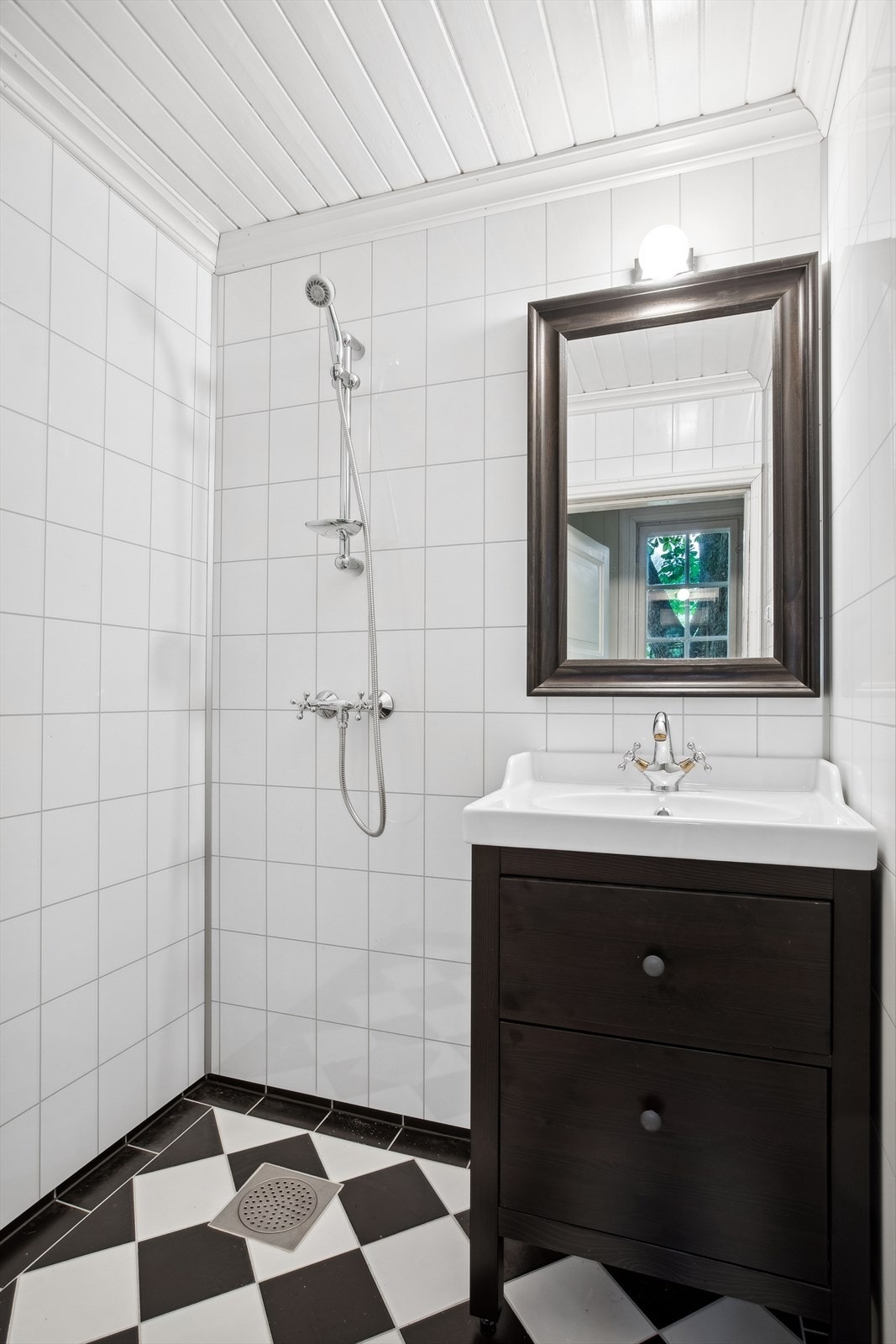 Lekkert bad med varme i gulv. Våtromsplater på vegger. Rommet fremstår som en romslig velværeavdeling som byr servant og dusj. Sort innredning. Galleribilde