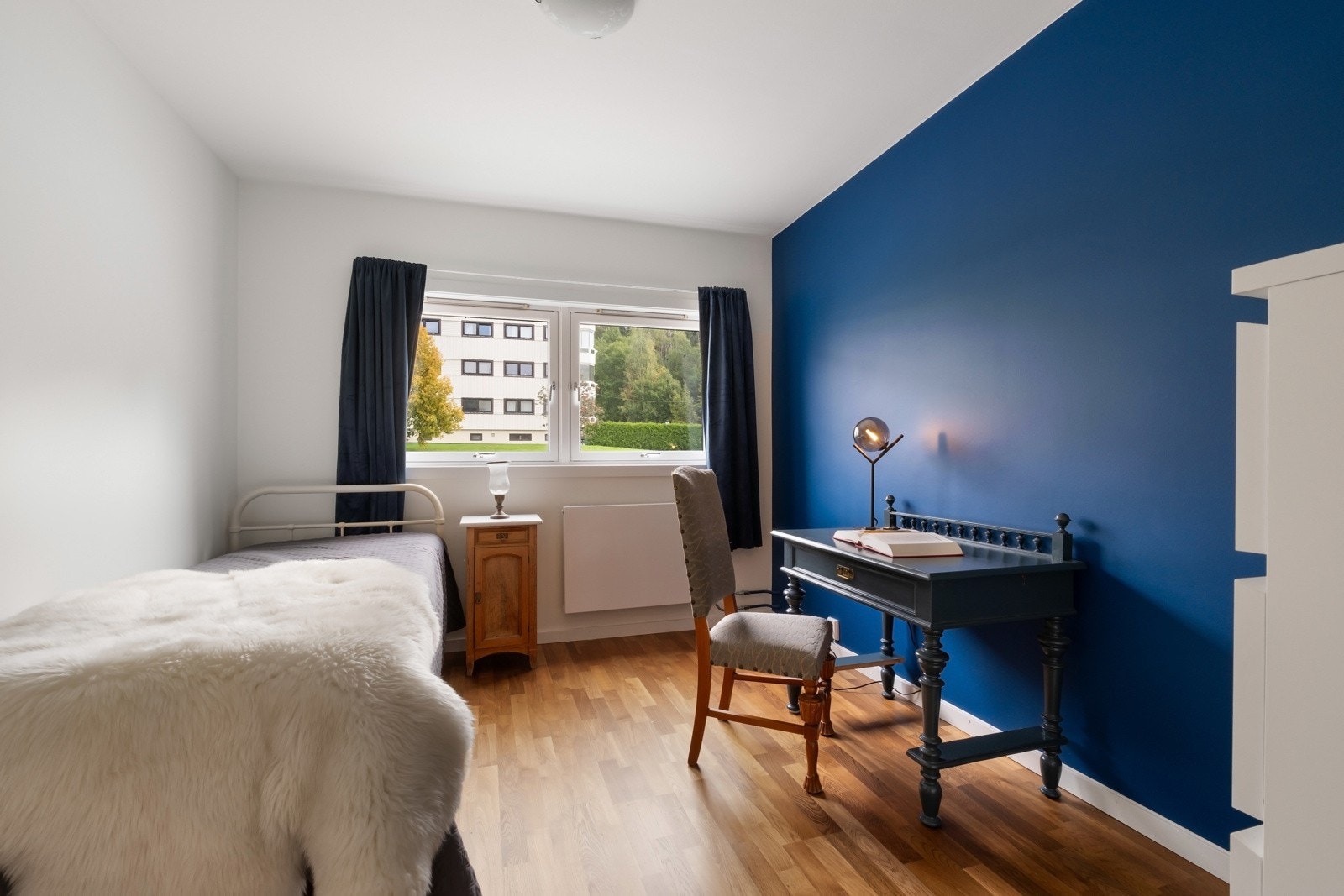 Soverom 2 fremstår som det perfekte ekstrarom med malte slette veggflater og parkett på gulv. Oppvarming via fjernvarme tilknyttet radiator under vinduet. Galleribilde