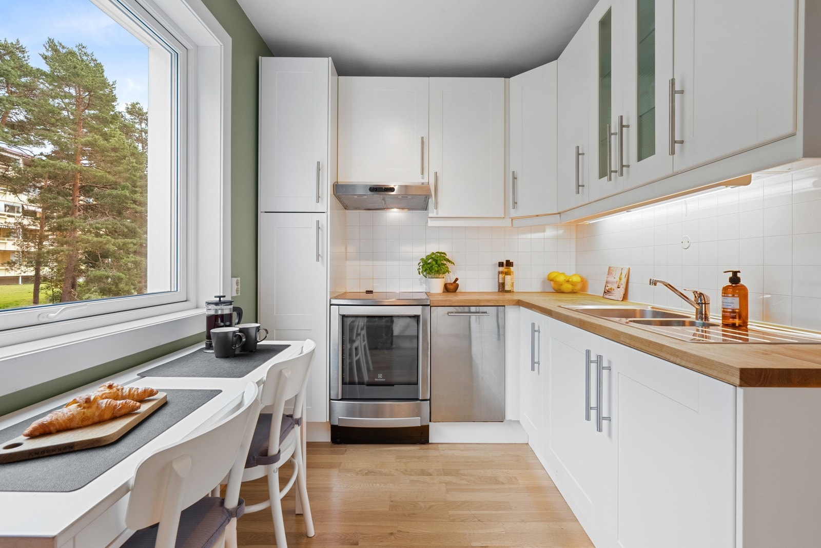 Innredningen er klassisk med to glasskap og hvite ettspeilsfronter for øvrig. Benkeplaten er i heltre og har nedfelt, dobbel oppvaskkum med avrenningsfelt. Galleribilde