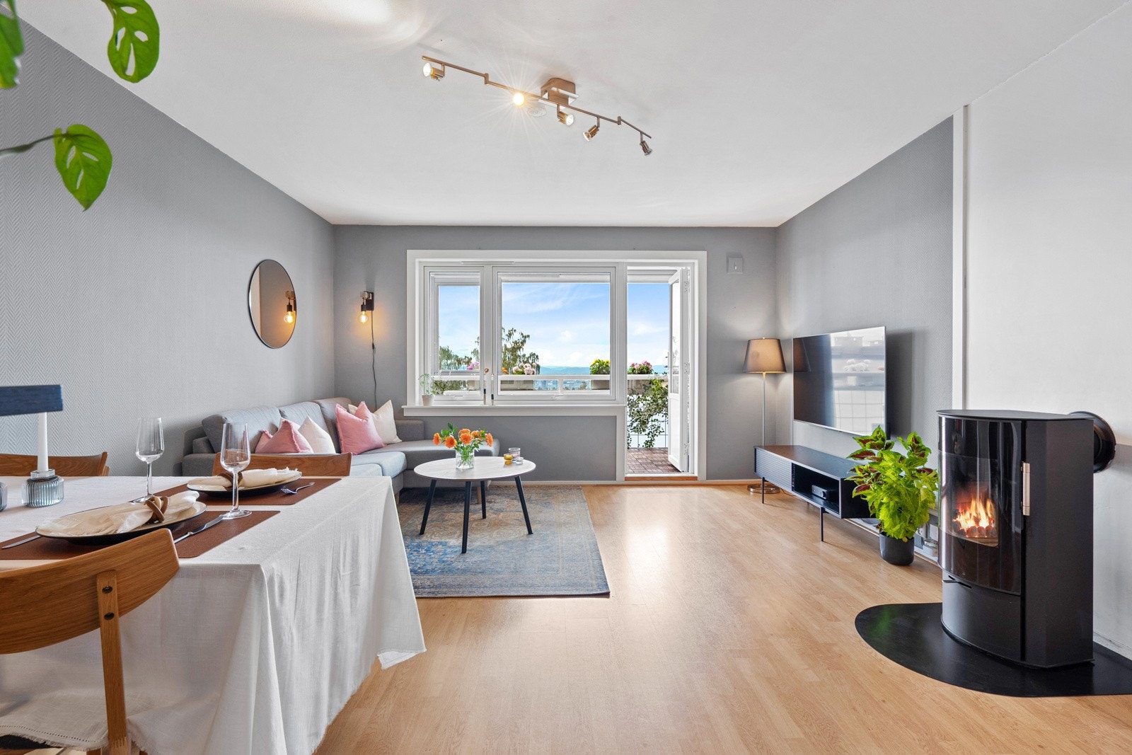 Stuen får godt med naturlig lysinnslipp fra store vindusflater. Vinduene og balkongdøren i leiligheten ble skiftet i 2020 i regi av borettslaget. Galleribilde