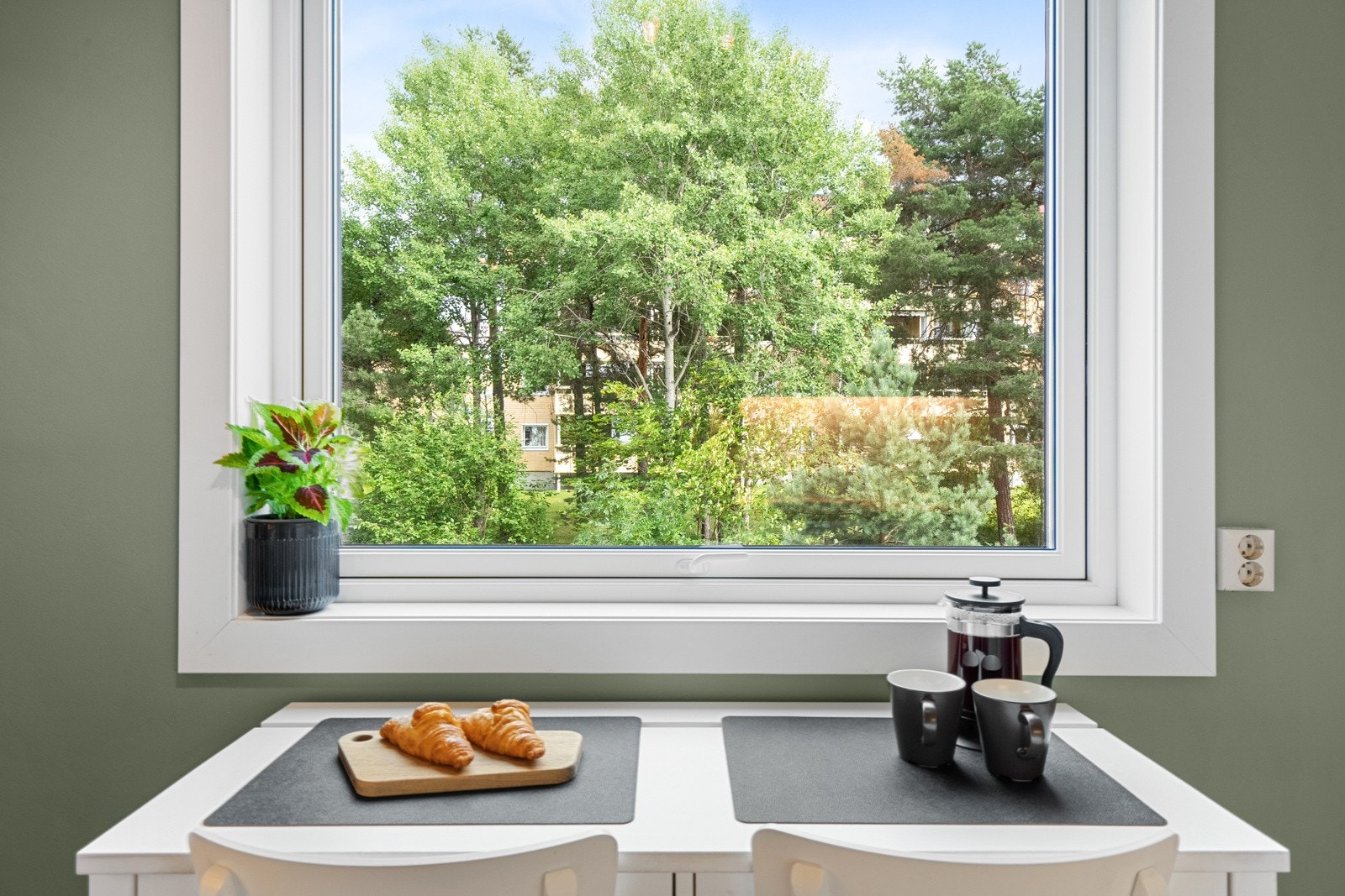 Ved vinduet er det plass til to stoler og et smalt spisebord. Et flott sted å starte dagen. Galleribilde