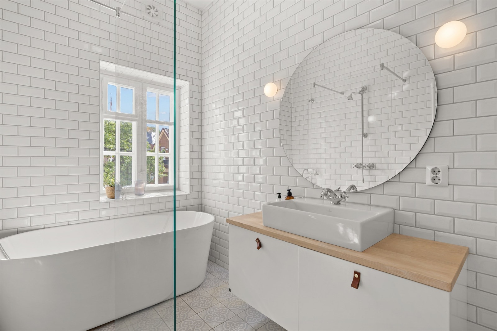 Begge bad og vaskerom har hvite metrofliser på veggene, mønstrede gulvfliser, gulvvarme og pen innredning. Galleribilde