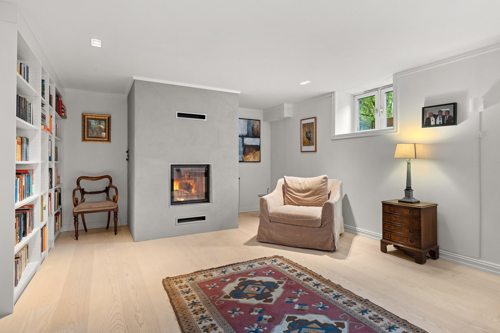 Kontoret i kjelleren har en lekker, innfelt peis, enstavs parkett, vannbåren gulvvarme og god møbelplass. Galleribilde