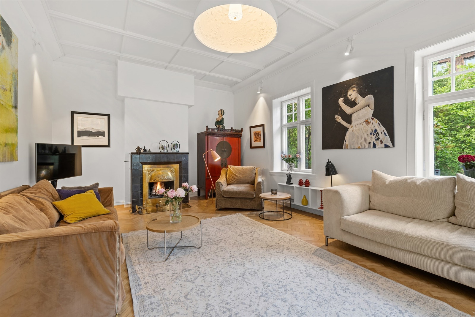 Stuen smykkes av en spesiell og vakker peis med omramming i messing og fliser. Galleribilde