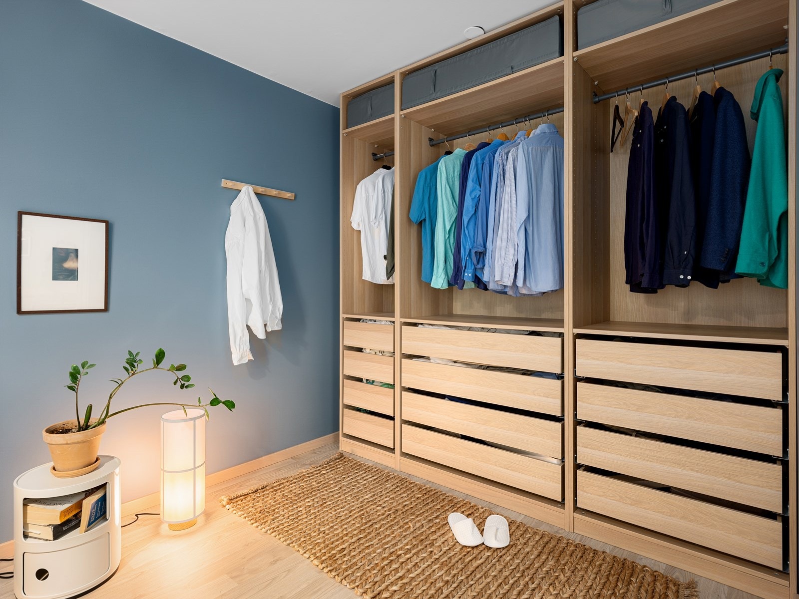 Innholdsrik og åpen garderobeløsning langs den ene veggen Galleribilde