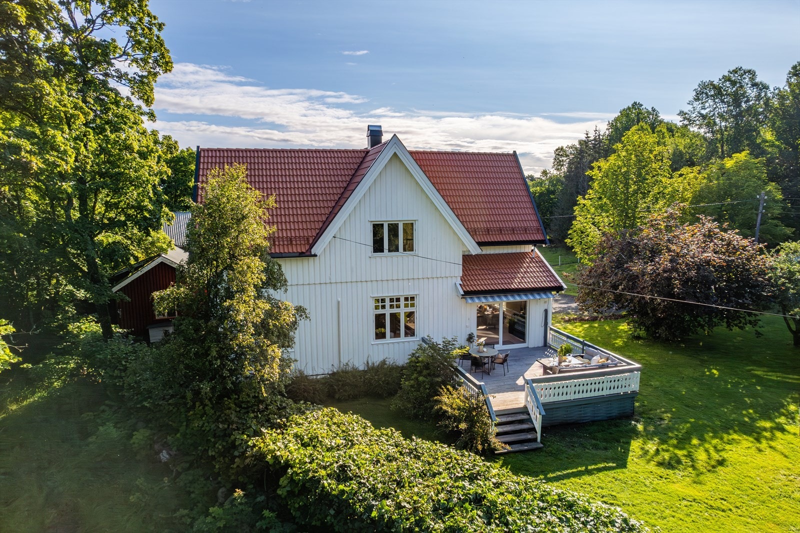 Terrasse i treverk ca 30 m2 utenfor stuen, med spilevegger og med trapp
til hagen. Galleribilde