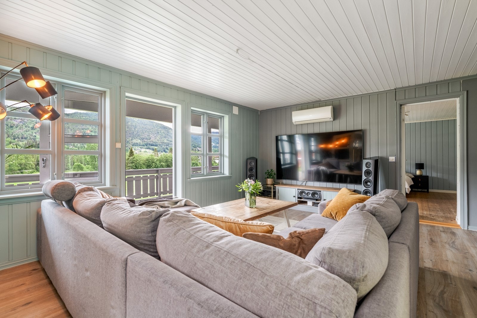 Pen, romslig stue med gode vindusflater og utgang til en romslig, overbygget veranda mot nordøst. God plass til sofagruppe og mediemøblement. Galleribilde