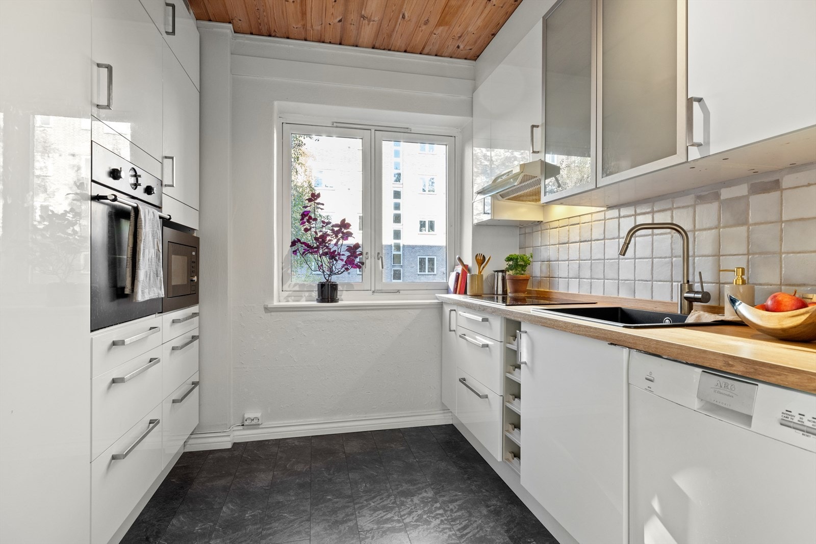 Separat kjøkken med vinylfliser på gulv og malte veggflater Galleribilde