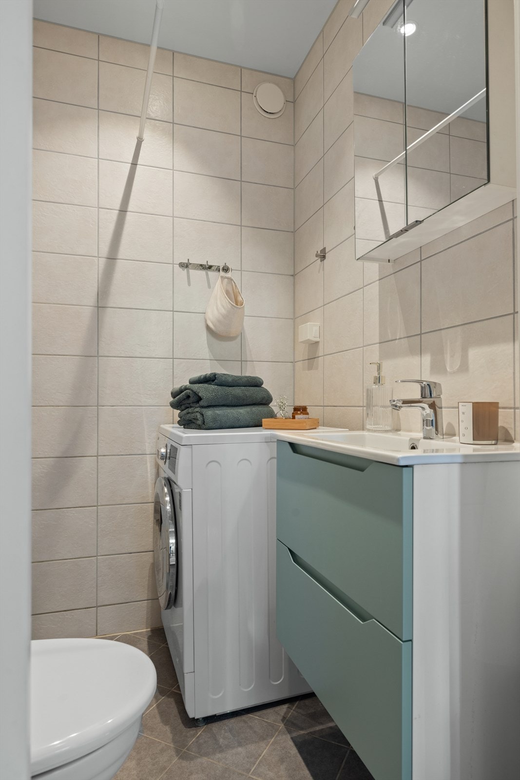 Badet er innredet med vegghengt toalett og en moderne baderomsinnredning med speilskap. Galleribilde