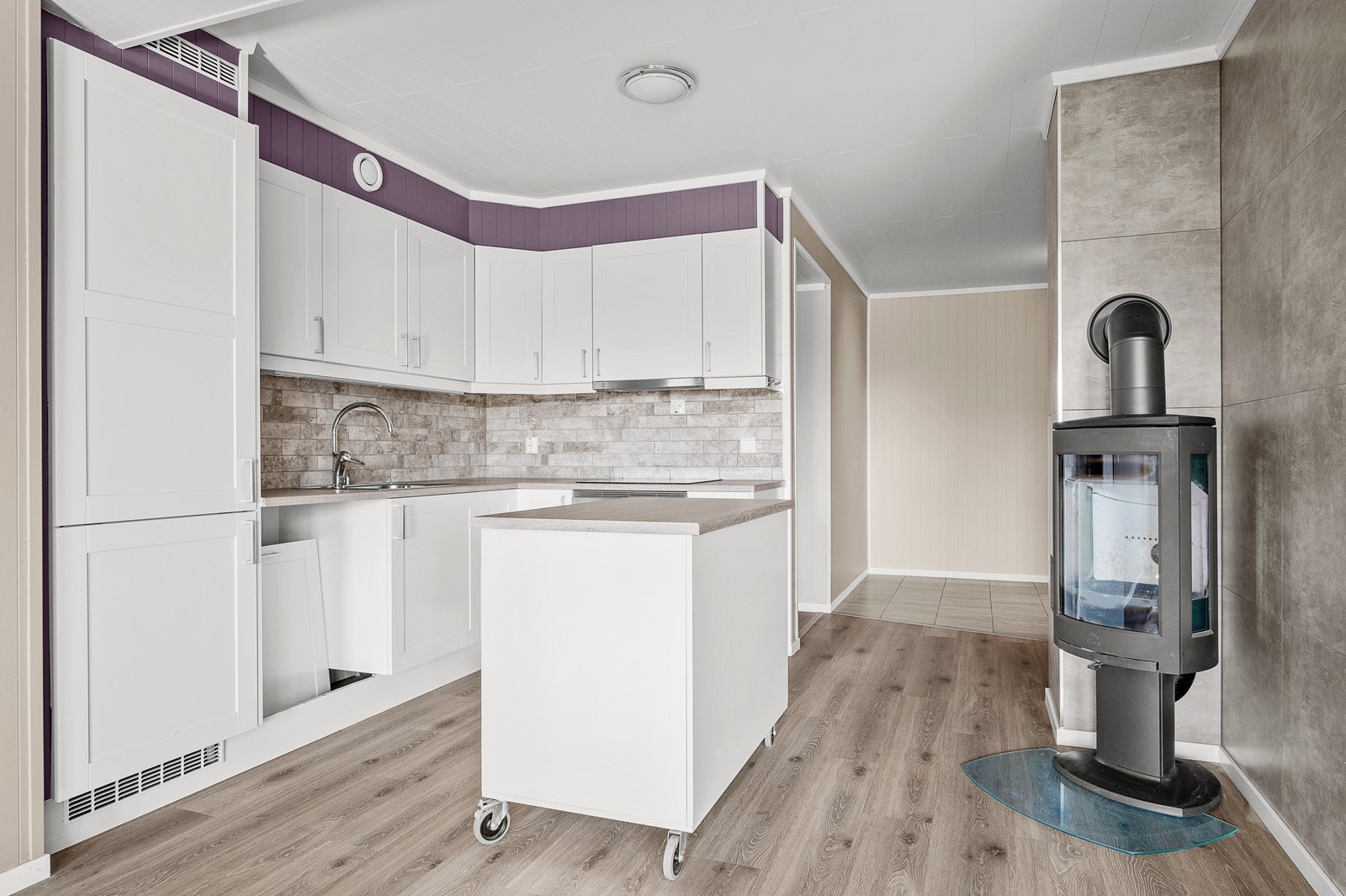 Pent kjøkken med kjøkkenøy på hjul - i tillegg til varmepumpe og balansert ventilasjon er det peisovn Galleribilde