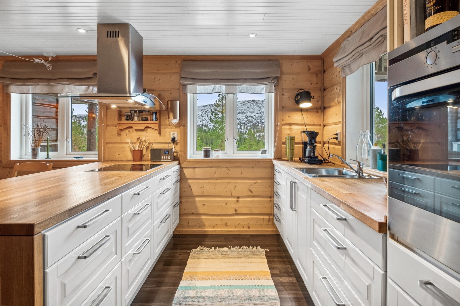 Lyst og innbydende kjøkken med integrerte hvitevarer. Hytta har ikke innlagt vann. Vann er lagt til utvendig vegg. Galleribilde