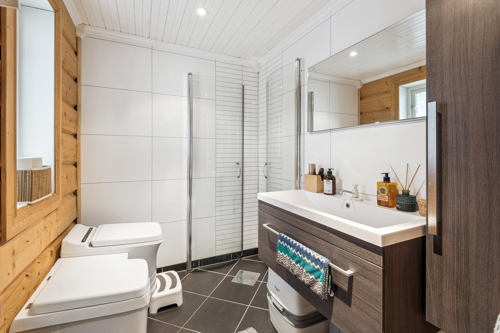 Lyst og pent bad med moderne inntrykk. Cinderella forbrenningstoalett og dusjløsning. Flislagt gulv og spotter i tak. Galleribilde