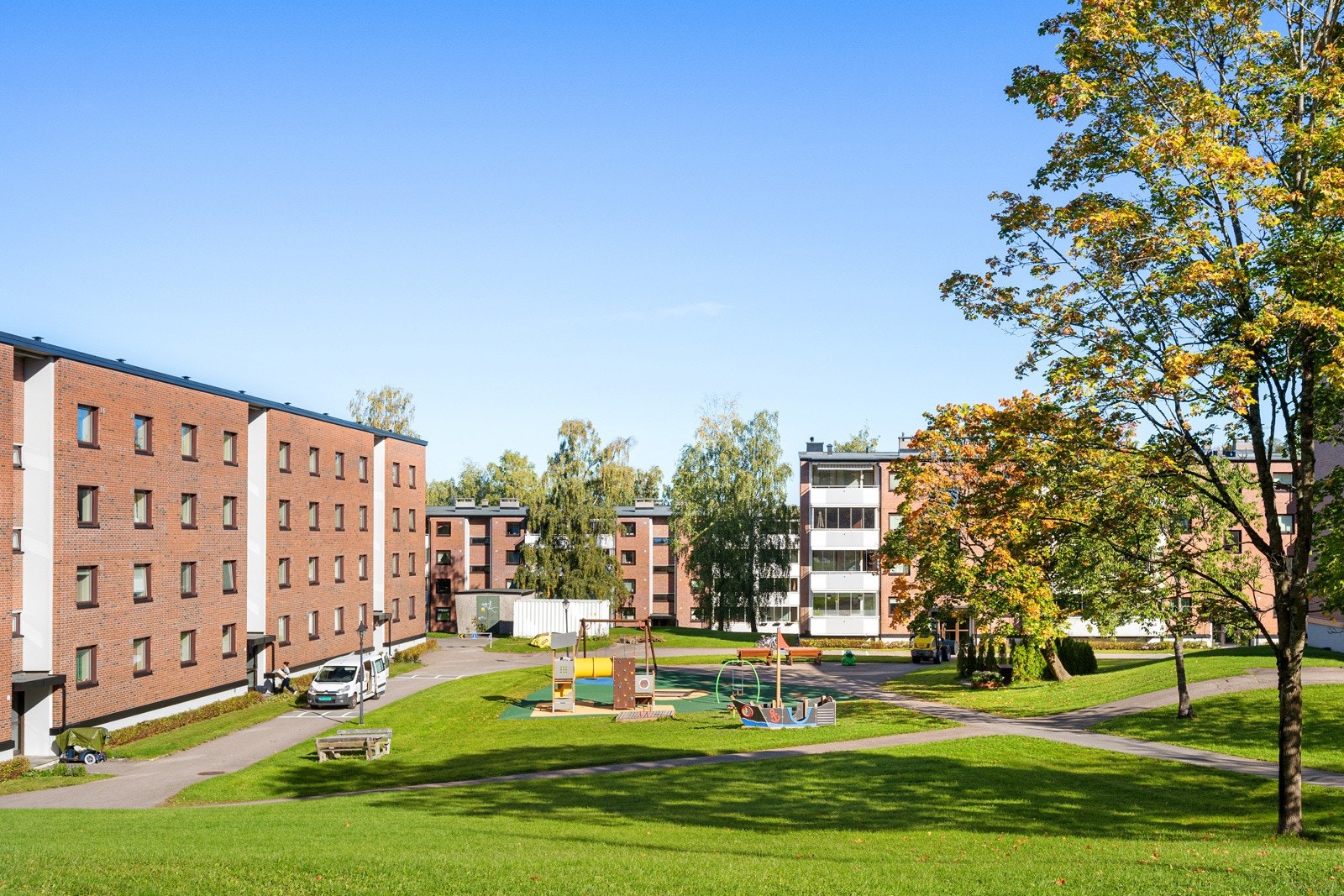 Pent opparbeidet fellesareal med internveier, sittegrupper, plen og beplantning. Galleribilde