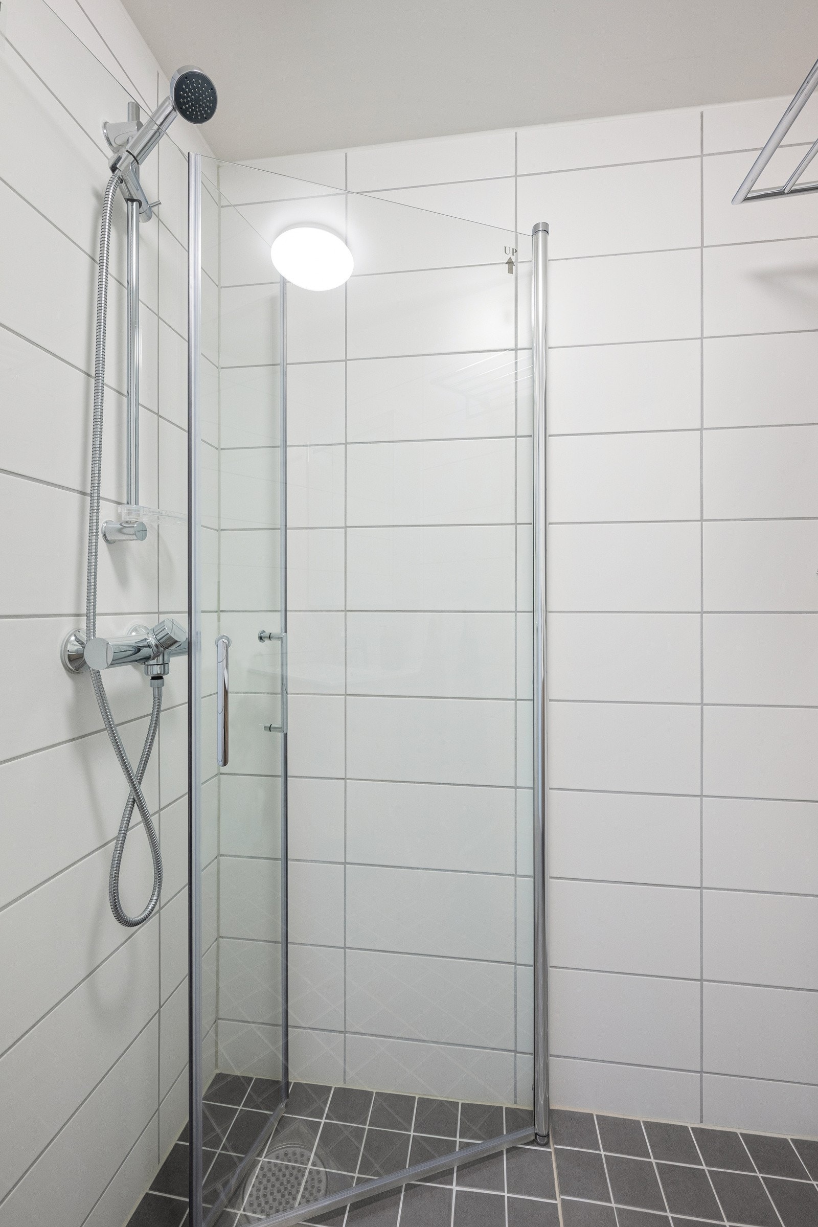 Badet utstyrt med servantinnredning, enkelservant med ett-greps armatur, dusj med dusjdører, speilskap. Galleribilde