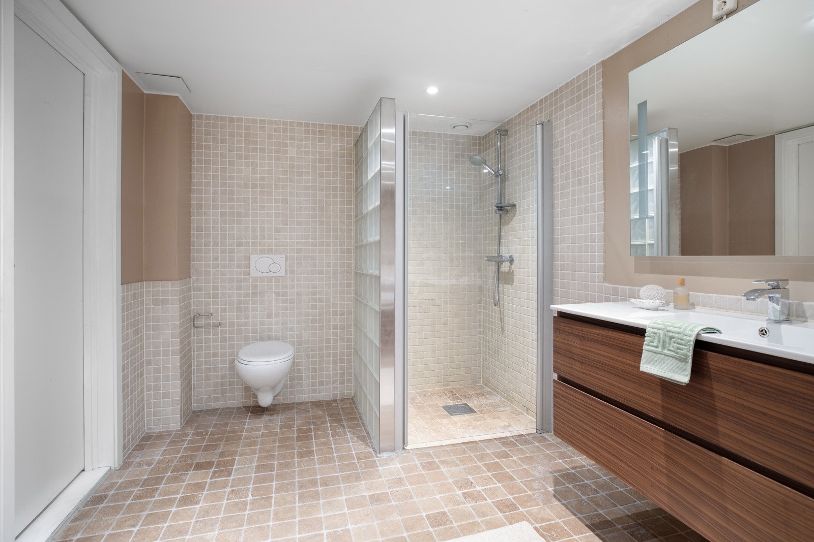 Baderomsinnredningen består av servantskap og servant, speil med lysarmatur, toalett, dusjhjørne og innbygd badekar Galleribilde