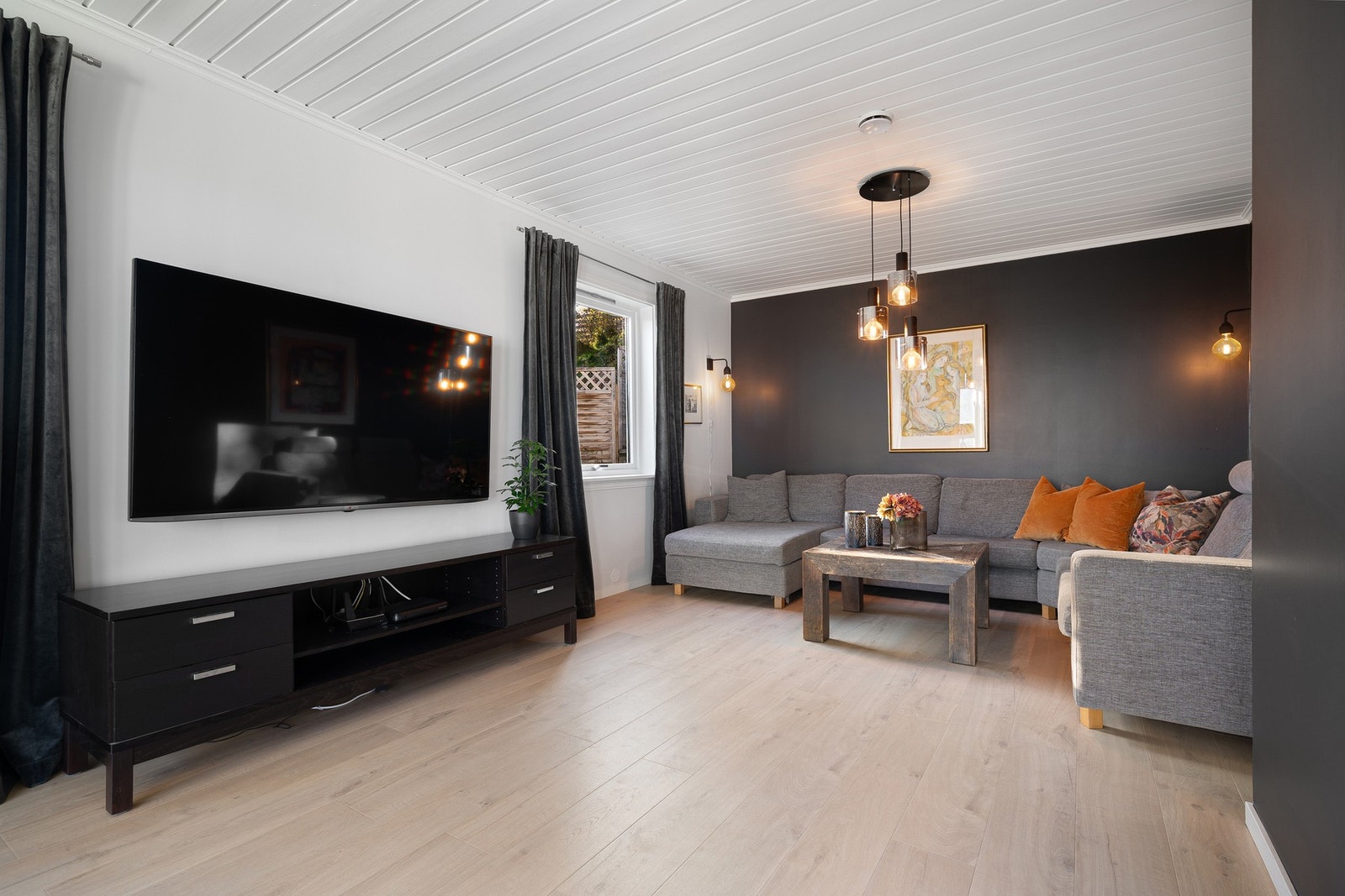 Mørke vegger gir fin kontrast til den ellers lyse stuen - og står i stil til det lekre kjøkkenet du snart skal få se! Galleribilde