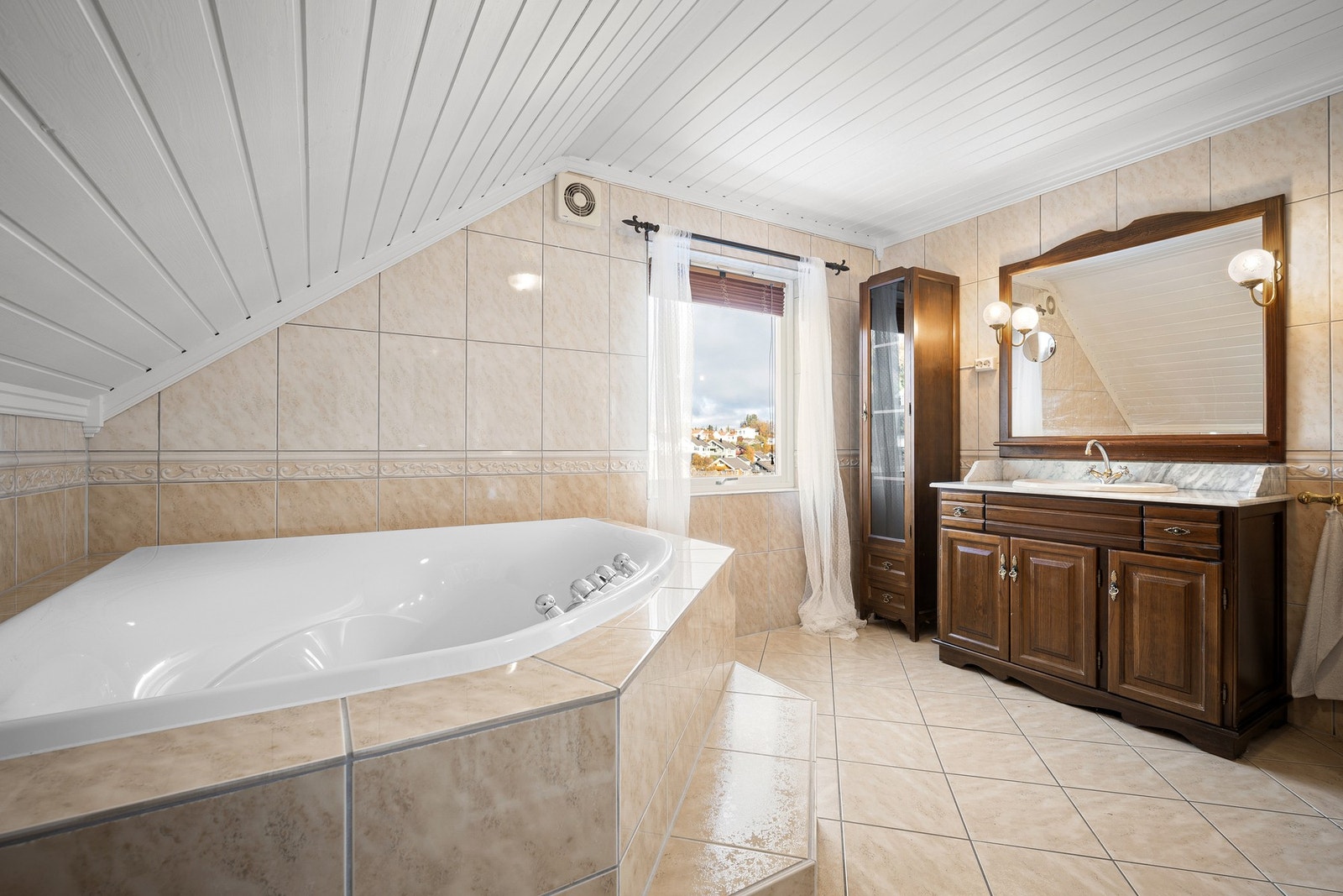 Innenfor hovedsoverommet finner du et romslig og delikat bad med flislagt gulv og vegger Galleribilde