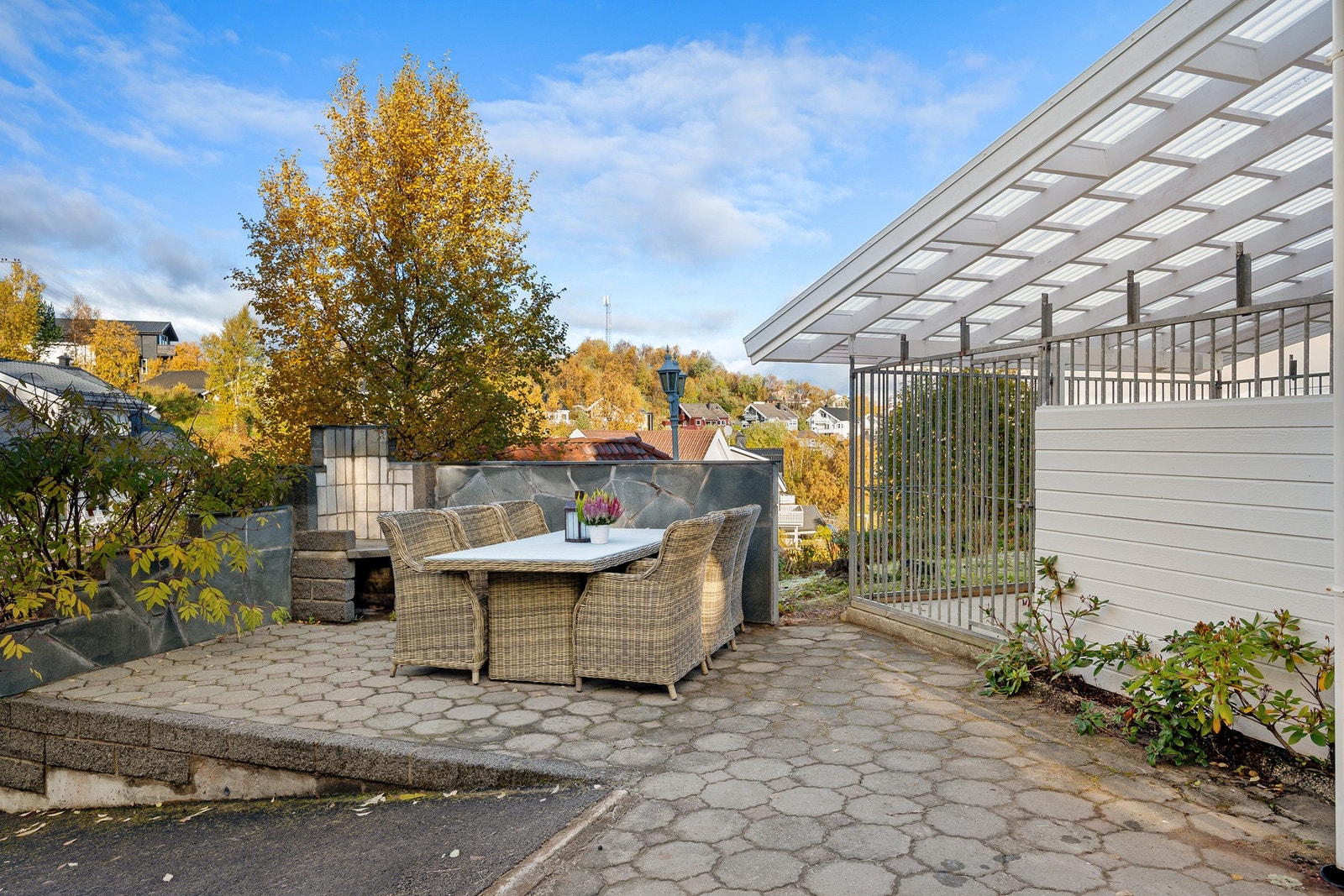 Hyggelig uteplass som er opparbeidet med brostein og en plassmurt peis Galleribilde